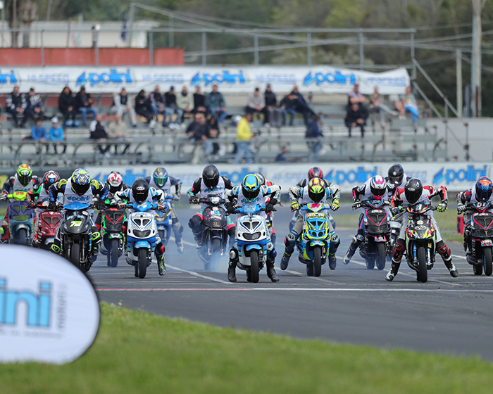 Gara Polini Italian Cup: griglia di partenza con piloti su scooter Polini, fumo dai pneumatici e pubblico sugli spalti.